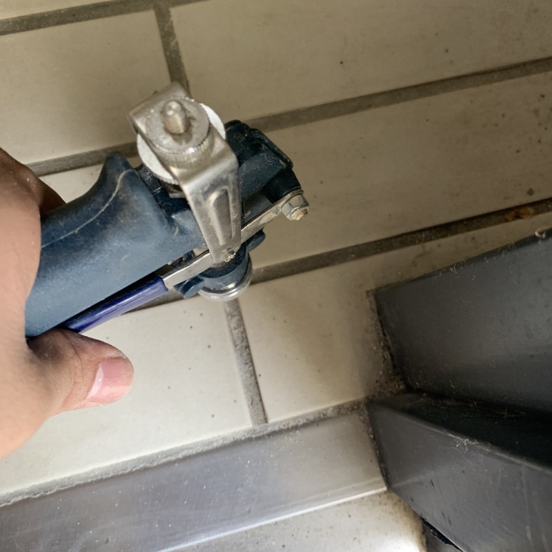 玄関の床にシロアリ駆除剤を注入する様子