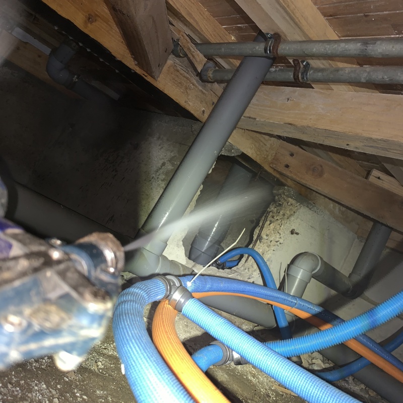 床下の基礎部分にシロアリ駆除剤を散布する様子