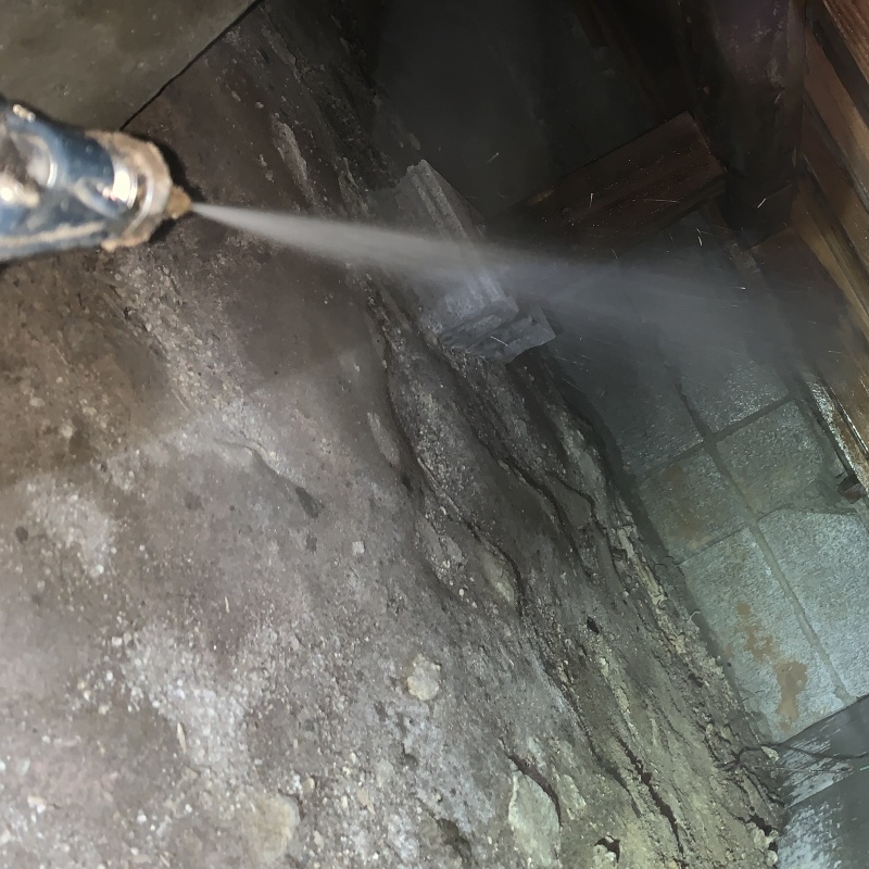 床下の基礎部分にシロアリ駆除剤を散布する様子