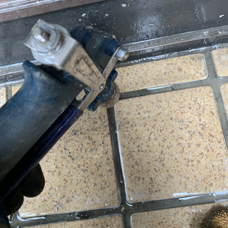 玄関の床にシロアリ駆除剤を注入する様子