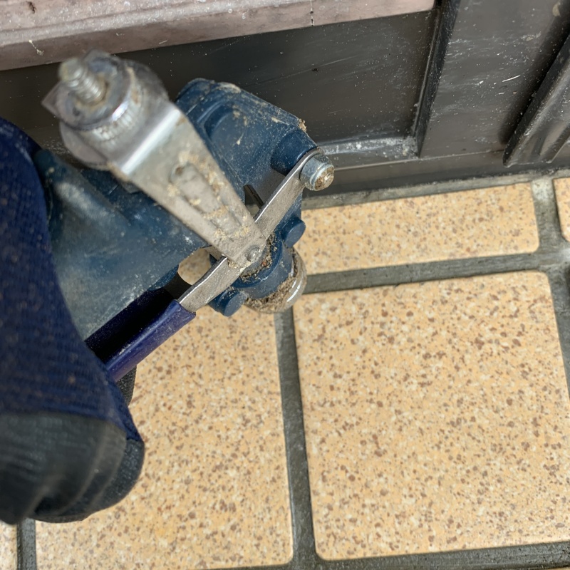 玄関の床にシロアリ駆除剤を注入する様子