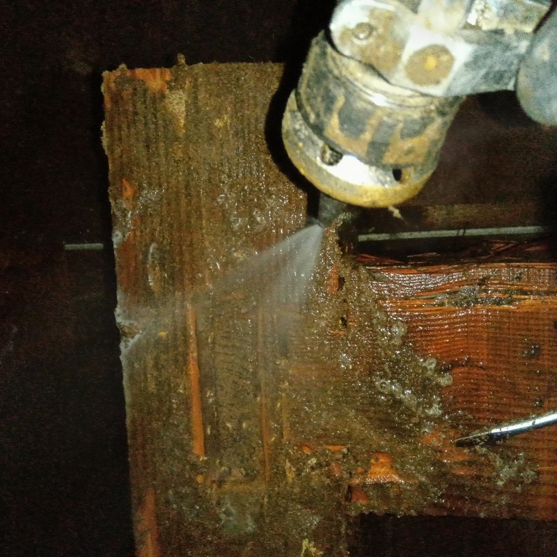 床下の木材にシロアリ駆除剤を散布する様子