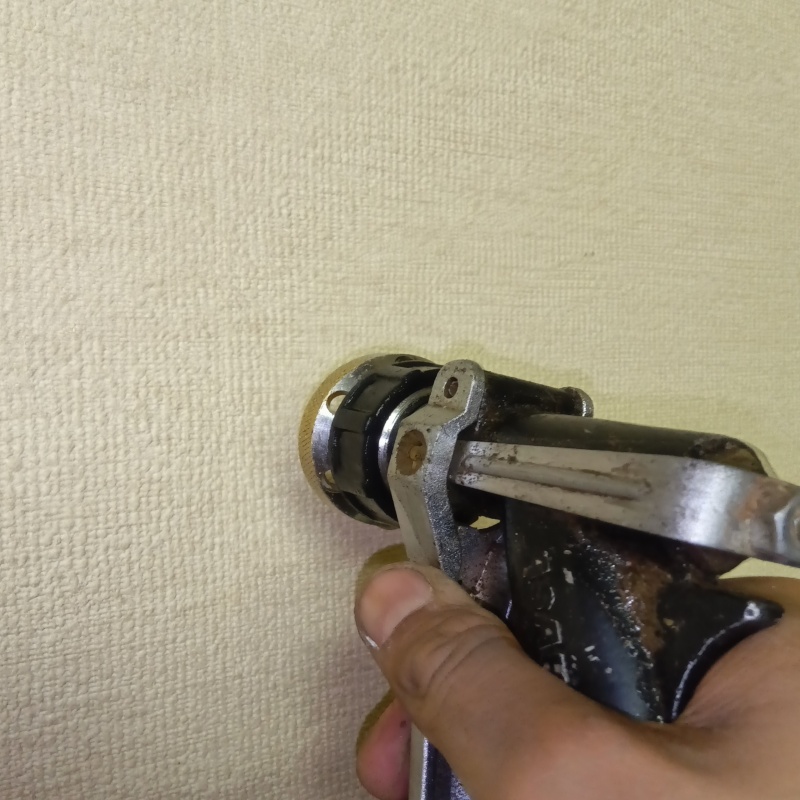 洗面所の壁にシロアリ駆除剤を注入する様子