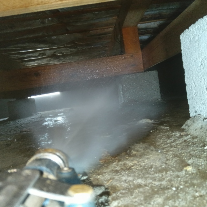 床下の土壌にシロアリ駆除剤を散布する様子