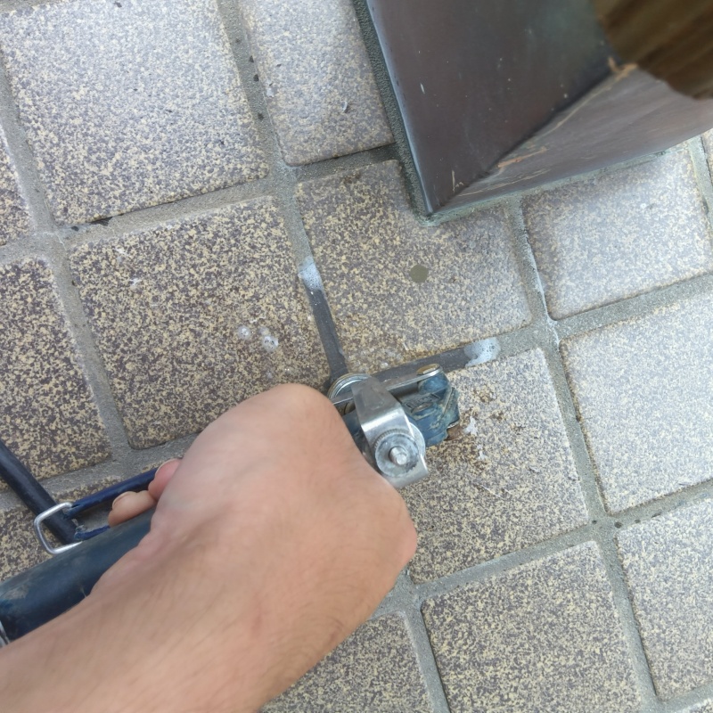 玄関の床にシロアリ駆除剤を注入する様子