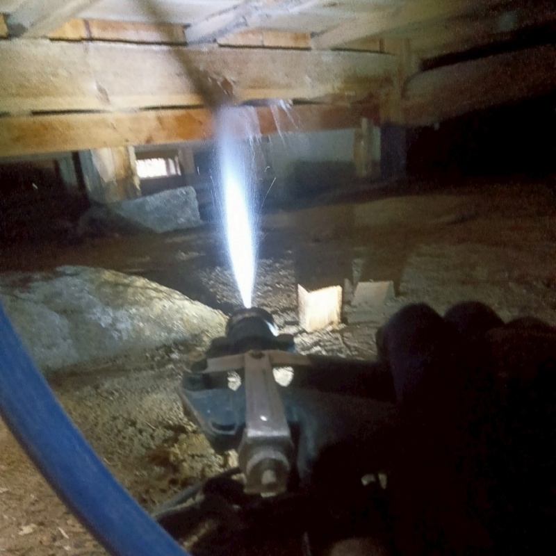 床下の木材にシロアリ駆除剤を散布する様子