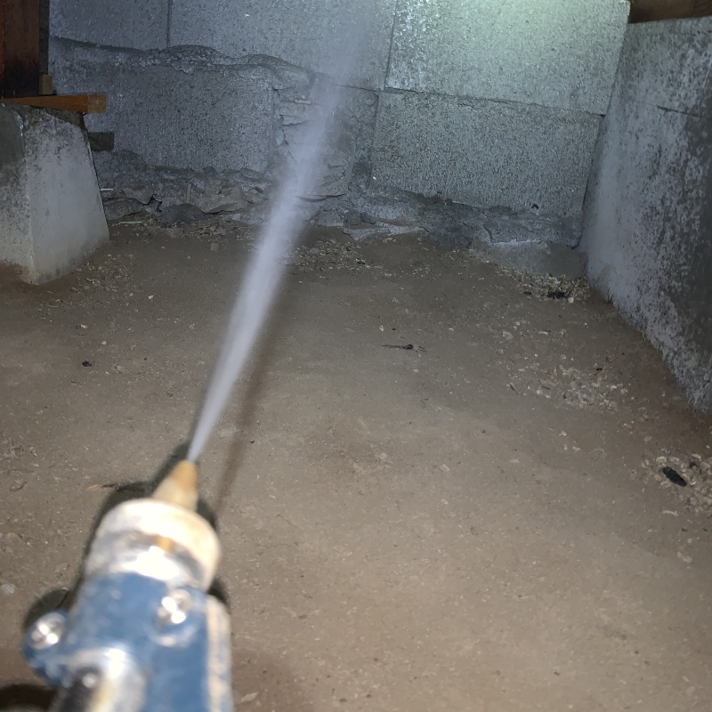 床下の基礎部分にシロアリ駆除剤を散布する様子