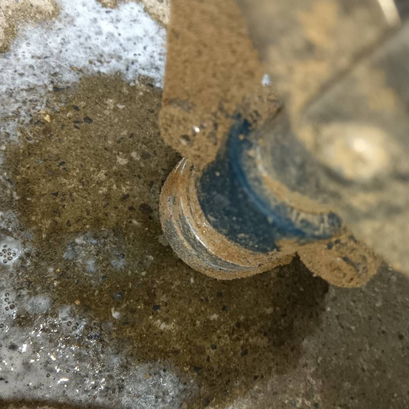 玄関の床にシロアリ駆除剤を注入する様子