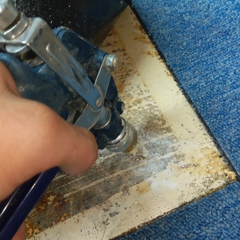 玄関の床にシロアリ駆除剤を注入する様子