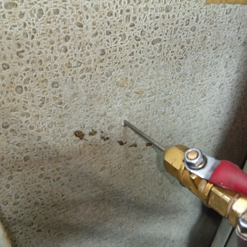 洗面所の壁にシロアリ駆除剤を注入する様子