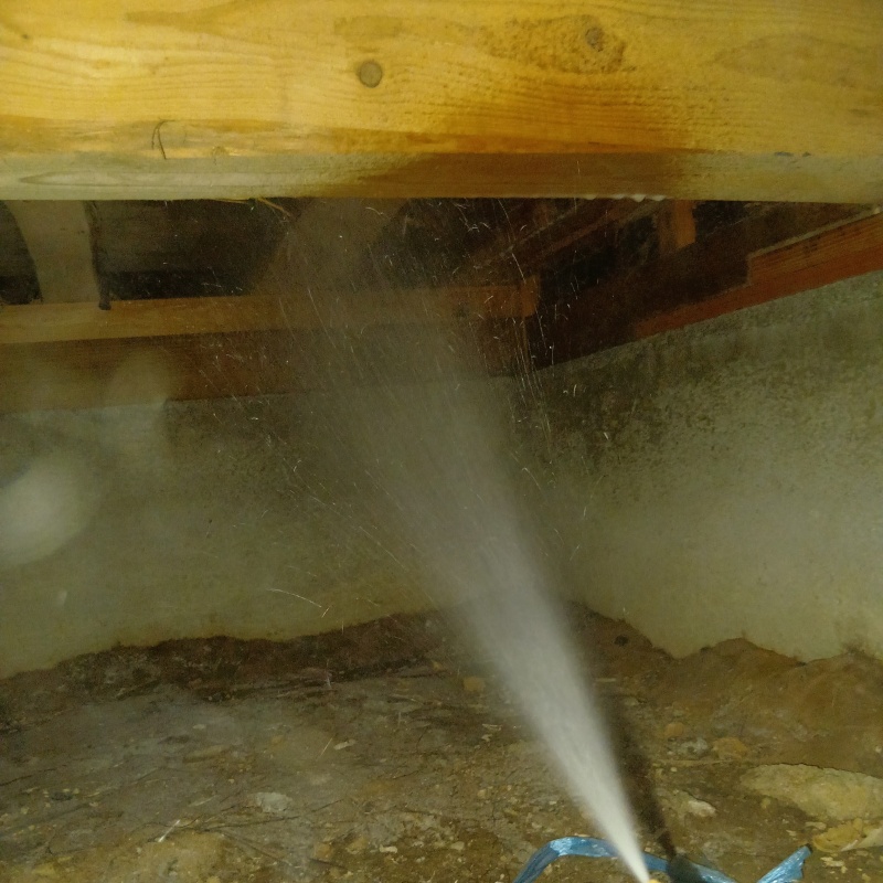 床下の木材にシロアリ駆除剤を散布する様子