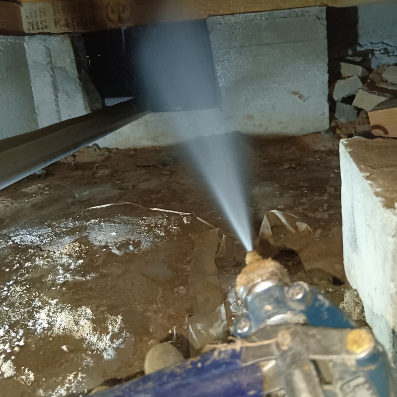 床下の基礎部分にシロアリ駆除剤を散布する様子