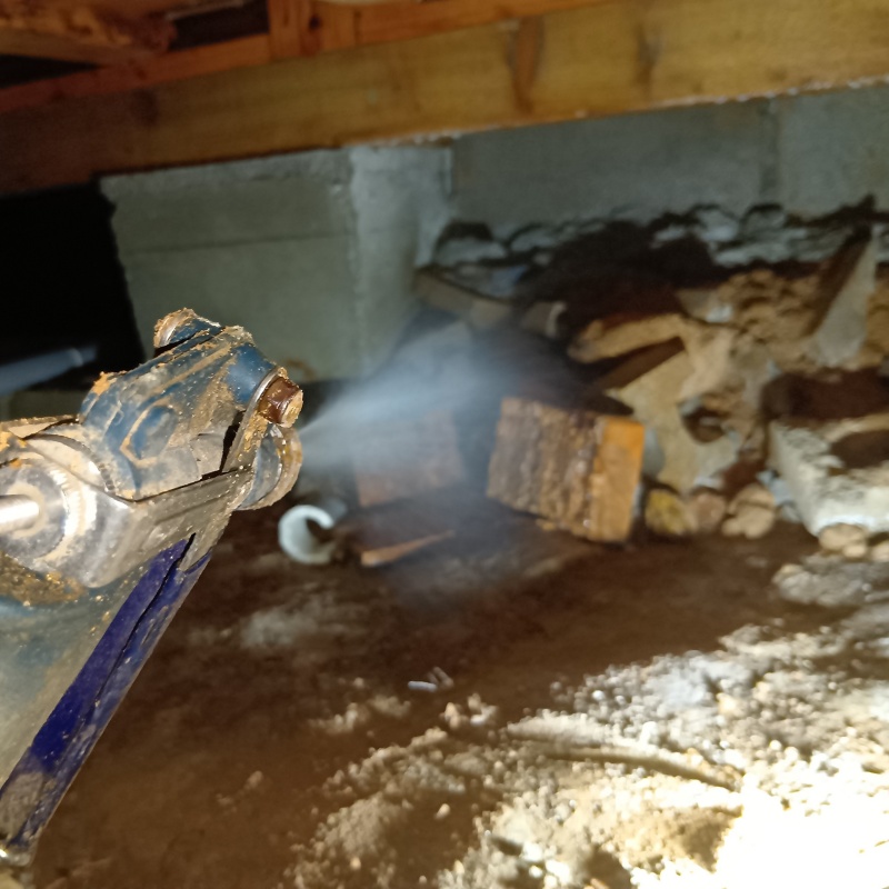 床下の土壌にシロアリ駆除剤を散布する様子