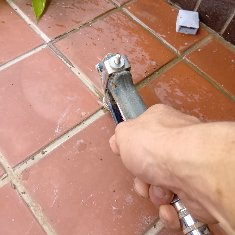 玄関の床にシロアリ駆除剤を注入する様子