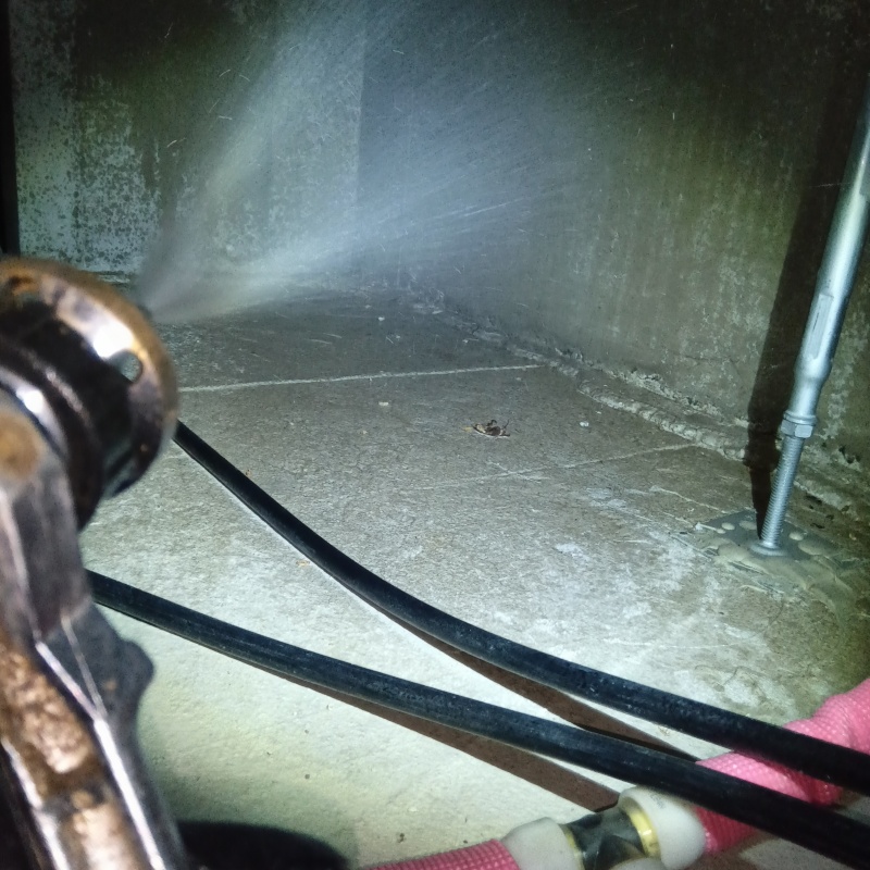 床下の基礎部分にシロアリ駆除剤を散布する様子