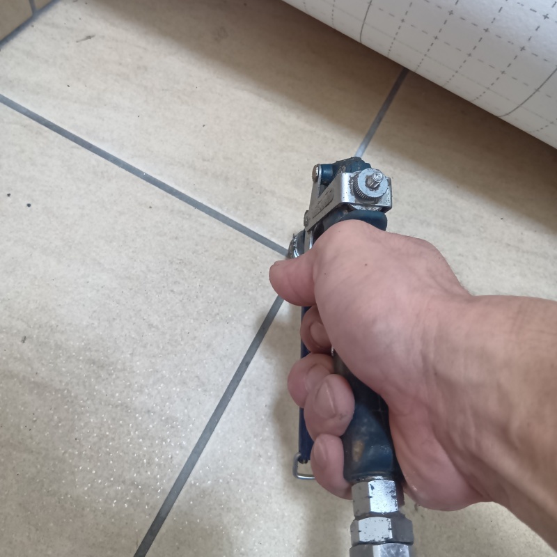 玄関の床にシロアリ駆除剤を注入する様子