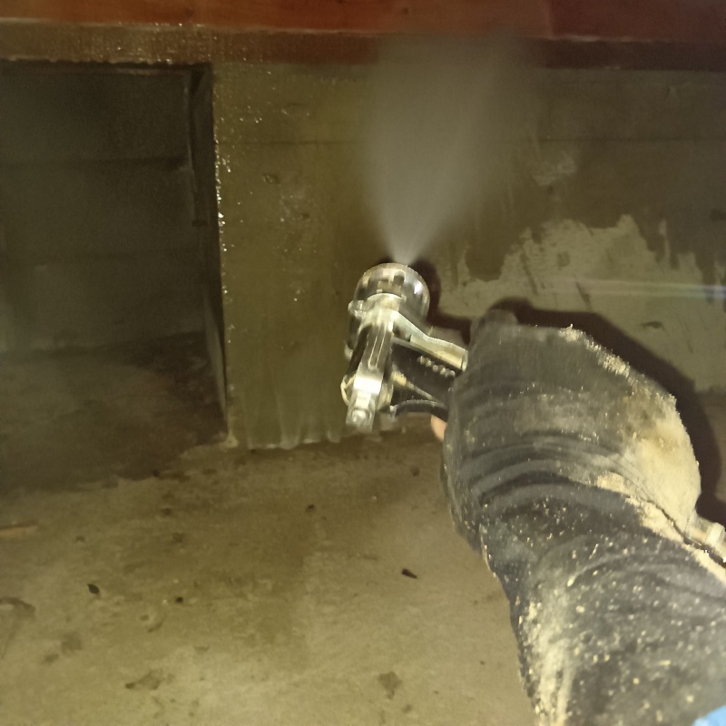 床下の基礎部分にシロアリ駆除剤を散布する様子