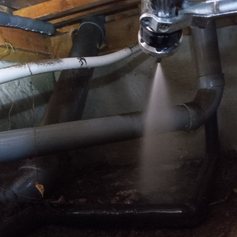 床下の土壌にシロアリ駆除剤を散布する様子