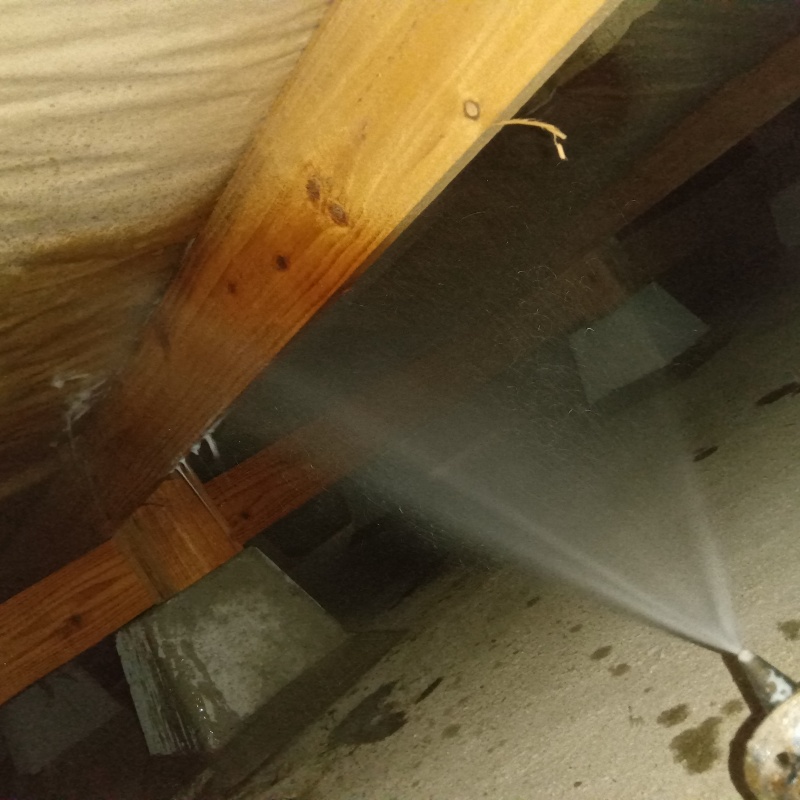 床下の木材に防蟻剤を散布する様子