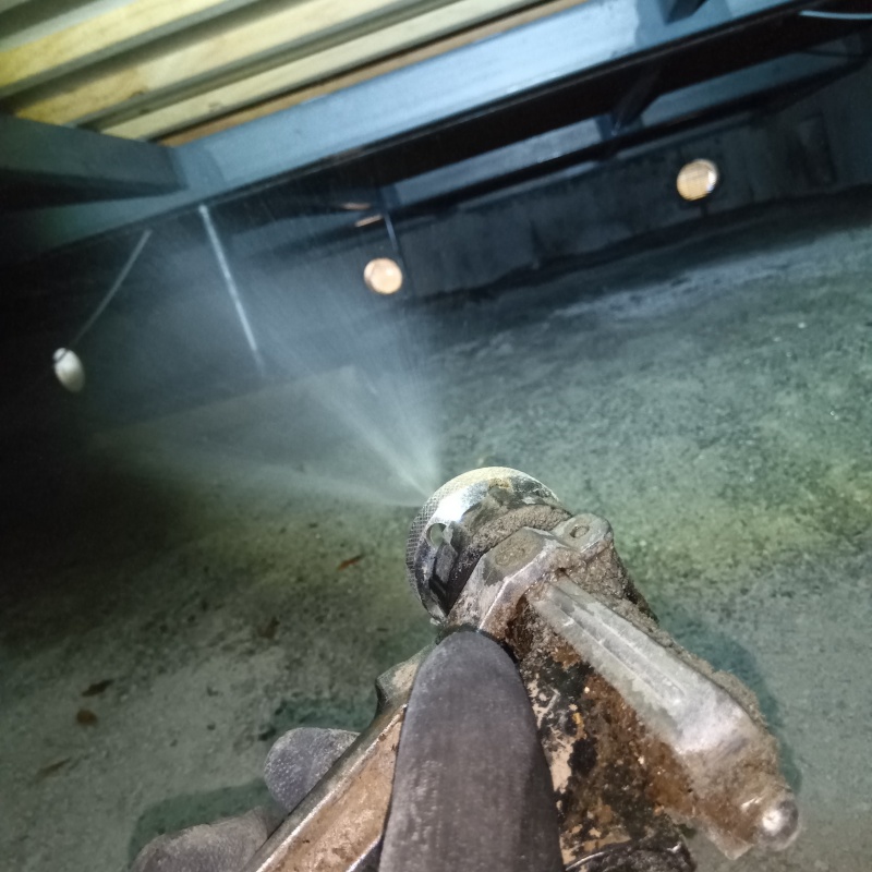 床下の土壌にシロアリ駆除剤を散布する様子