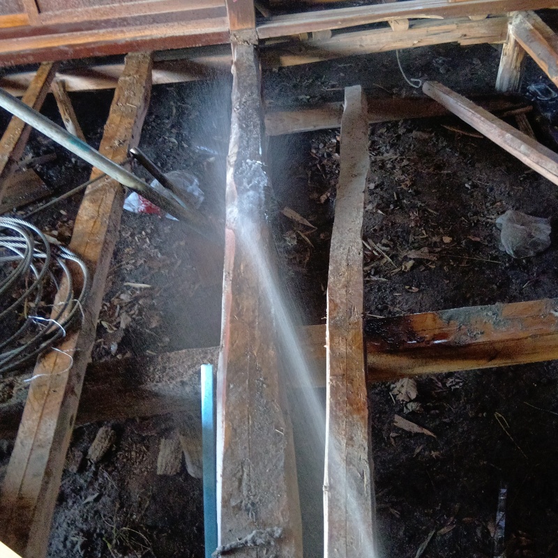 床下の木材にシロアリ駆除剤を散布する様子