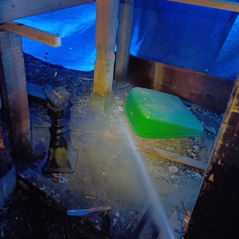 床下の土壌にシロアリ駆除剤を散布する様子