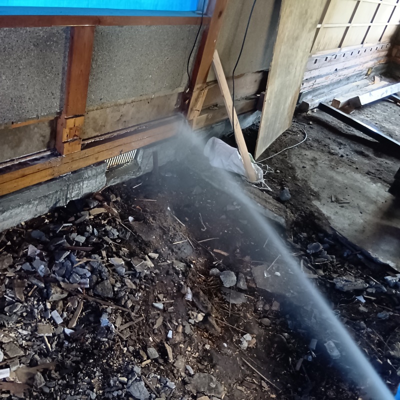 基礎まわりにシロアリ駆除剤を散布する様子