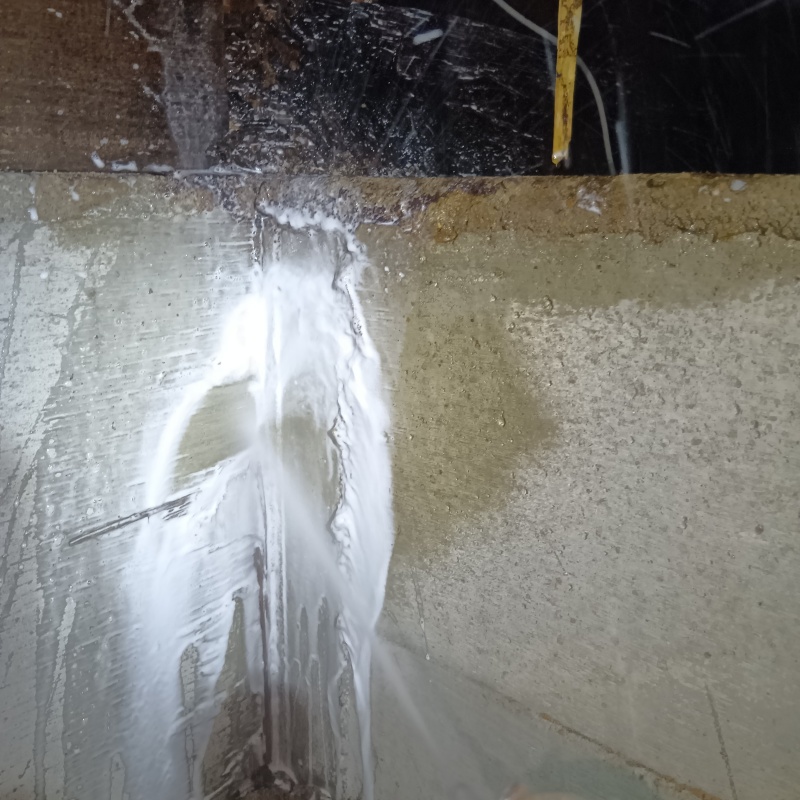 床下の基礎部分にシロアリ駆除剤を散布する様子