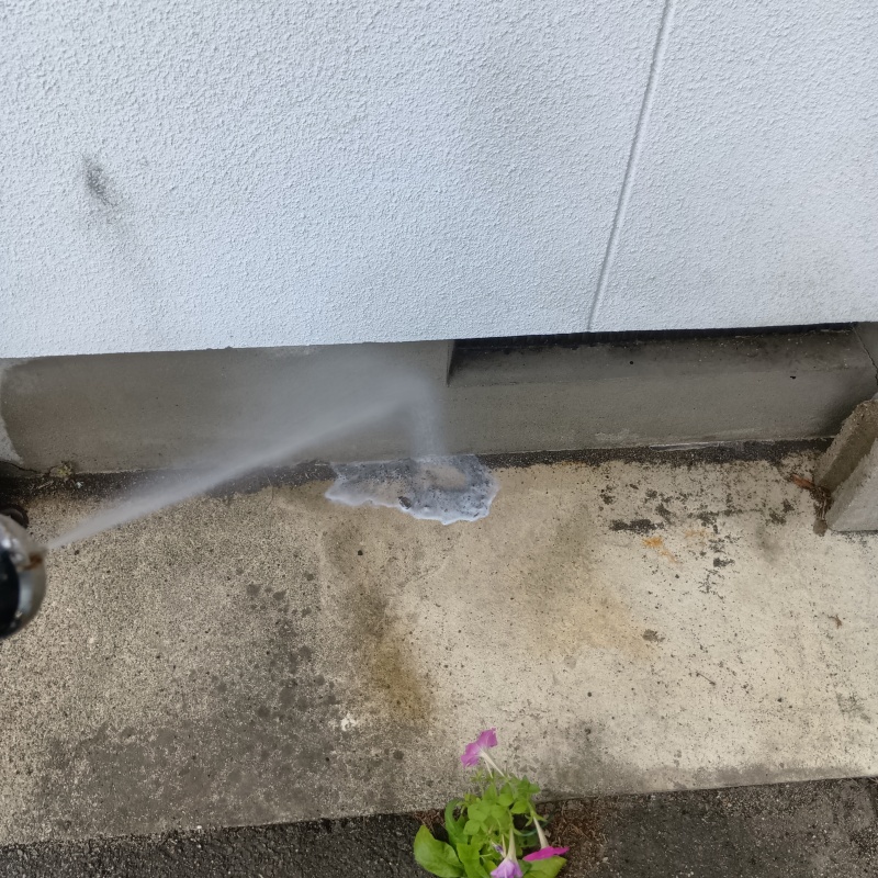 基礎まわりにシロアリ駆除剤を散布する様子