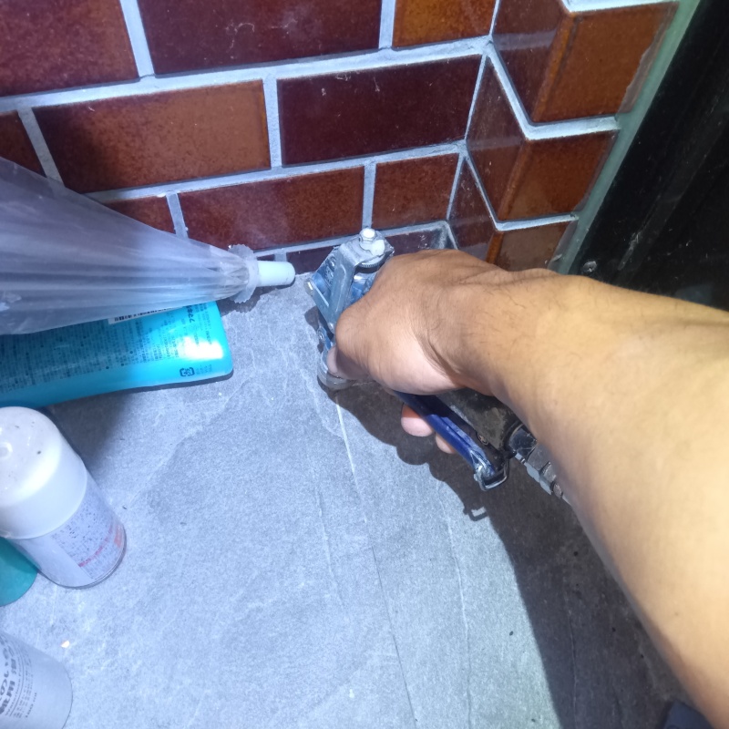 玄関の床にシロアリ駆除剤を注入する様子