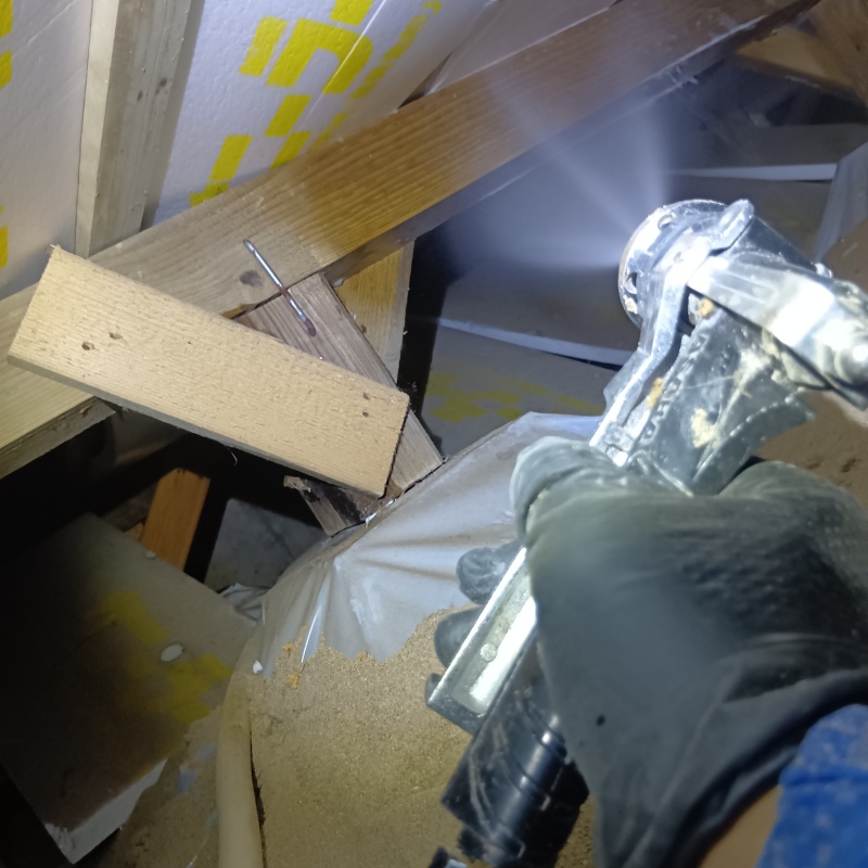 床下の木材にシロアリ駆除剤を散布する様子