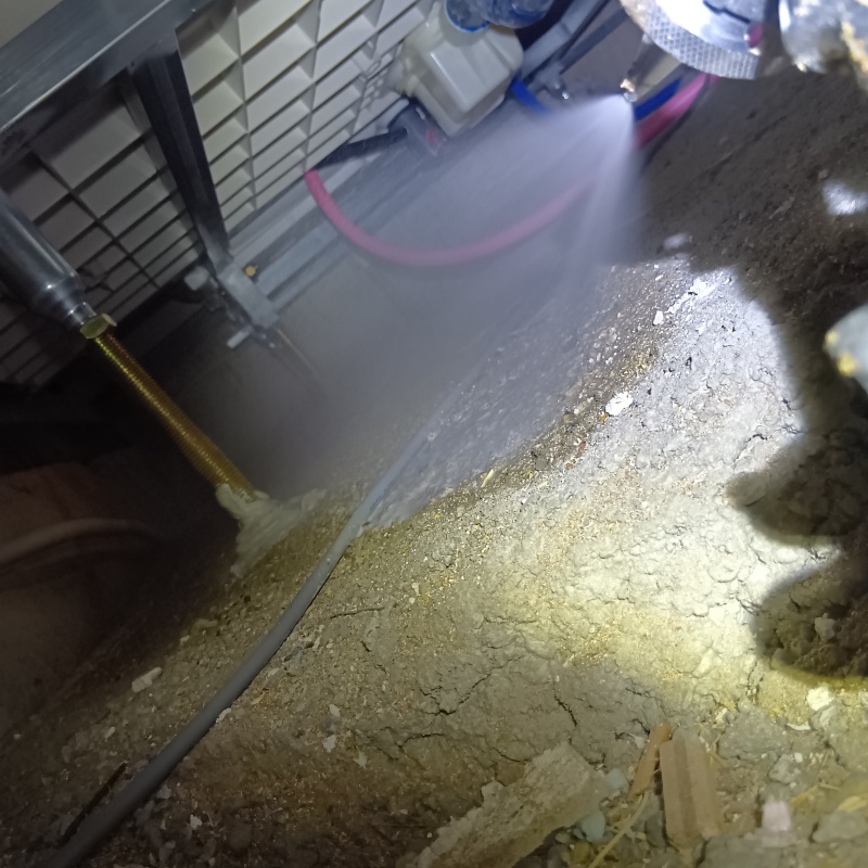 床下の土壌にシロアリ駆除剤を散布する様子