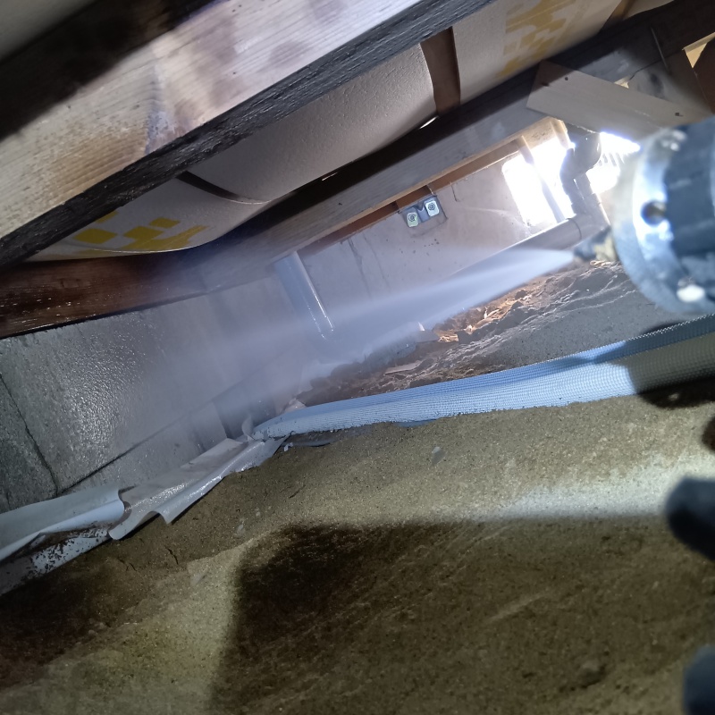 床下の基礎部分にシロアリ駆除剤を散布する様子