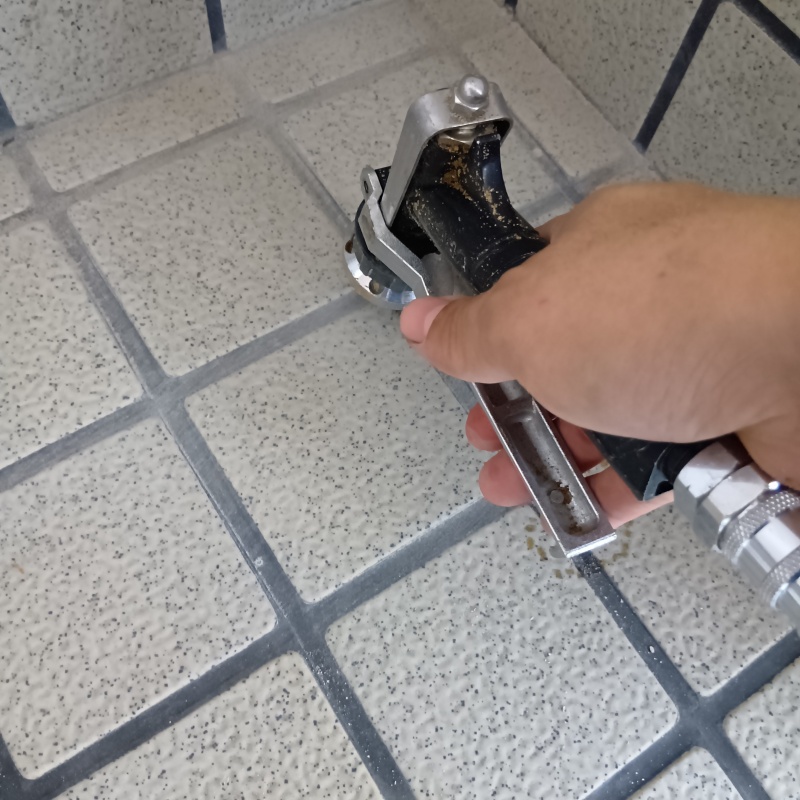 玄関の床にシロアリ駆除剤を注入する様子