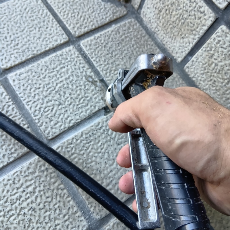 玄関の床にシロアリ駆除剤を注入する様子