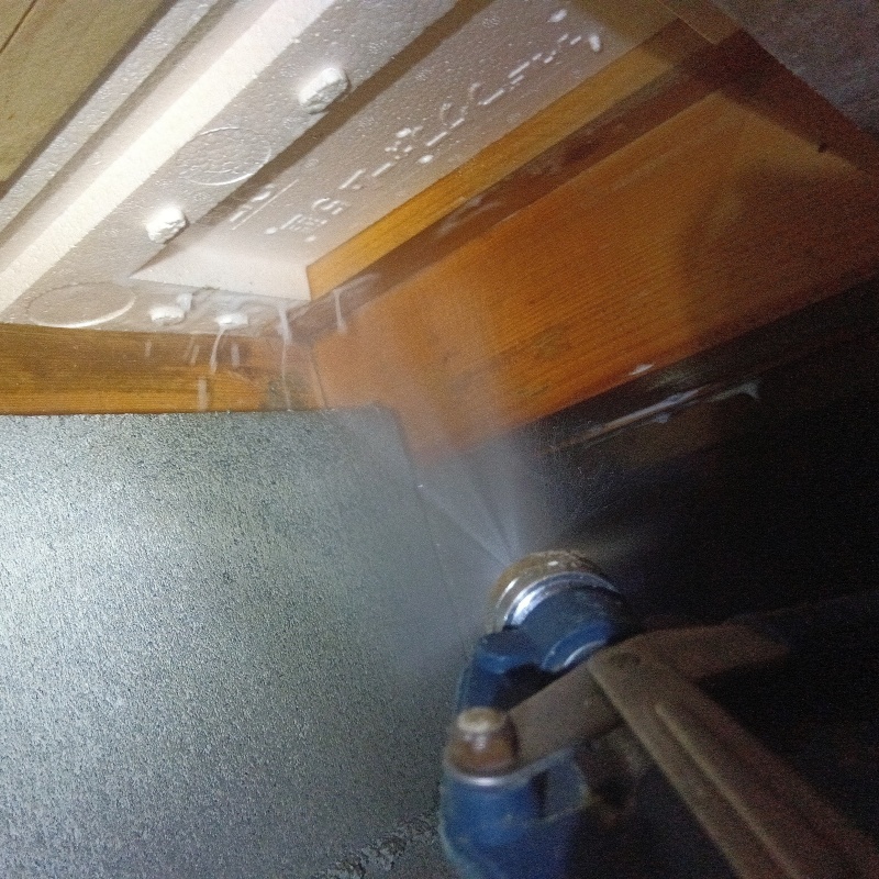 床下の木材にシロアリ駆除剤を散布する様子