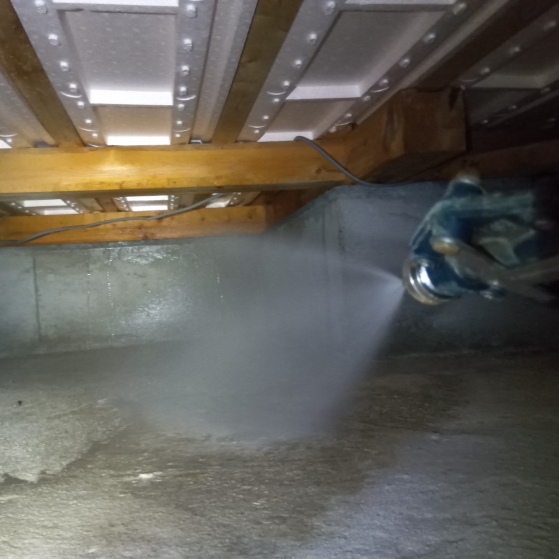 床下の基礎部分にシロアリ駆除剤を散布する様子