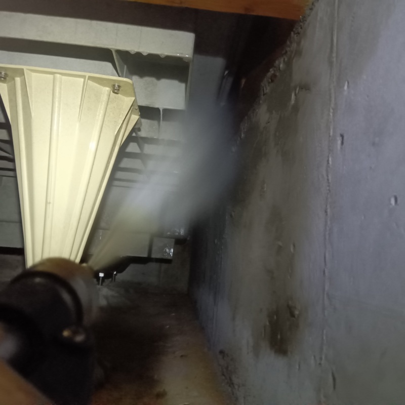 床下の基礎部分にシロアリ駆除剤を散布する様子