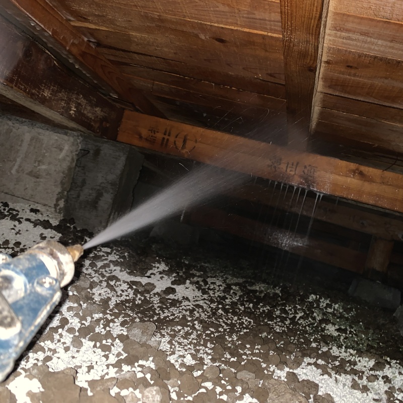 床下の木材にシロアリ駆除剤を散布する様子
