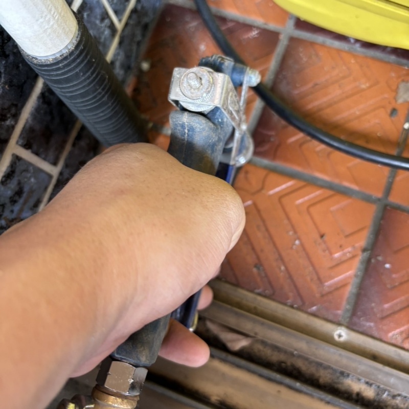 玄関の床にシロアリ駆除剤を注入する様子