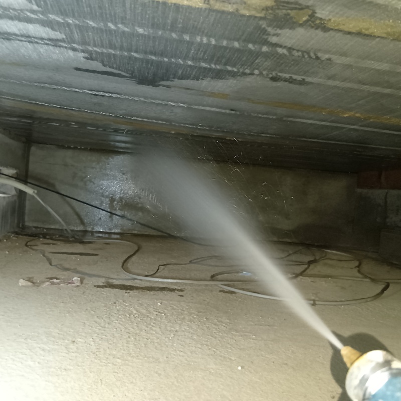 床下の基礎部分にシロアリ駆除剤を散布する様子