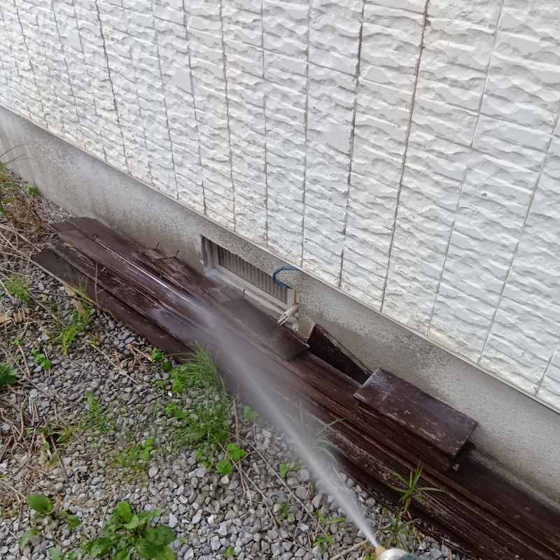 基礎まわりにシロアリ駆除剤を散布する様子