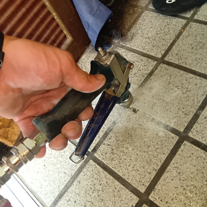 玄関の床にシロアリ駆除剤を注入する様子