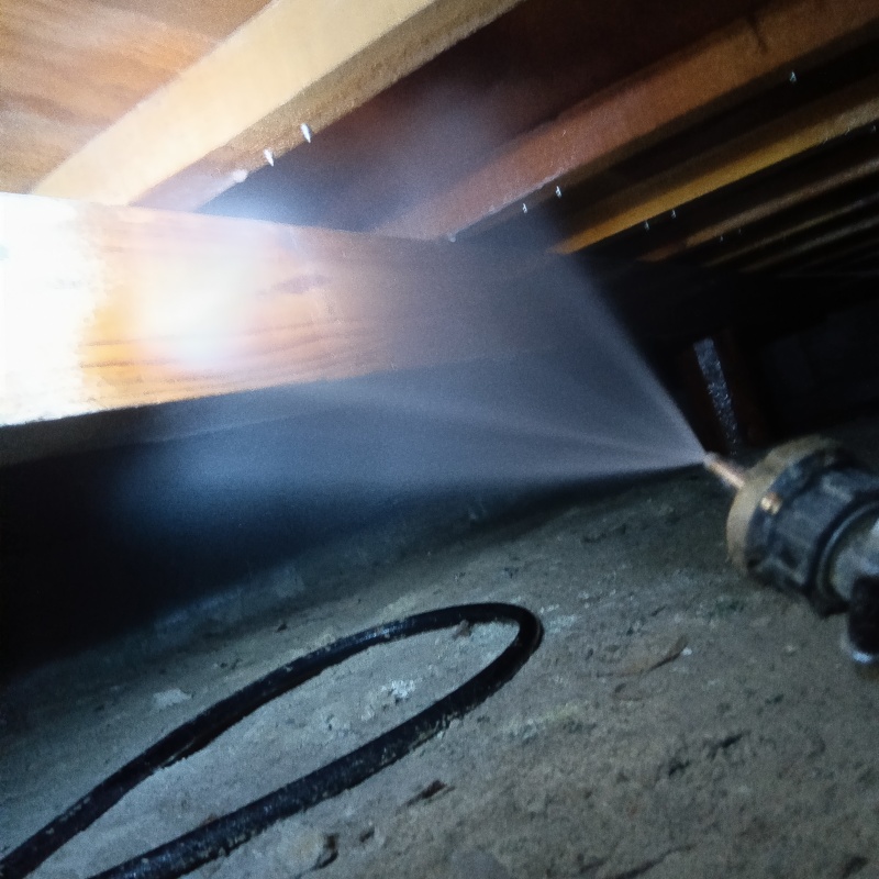 床下の木材に防蟻剤を散布する様子