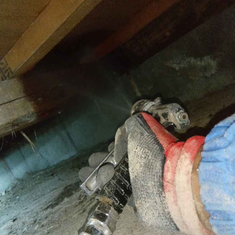 床下の地面や基礎に防蟻剤を散布する様子