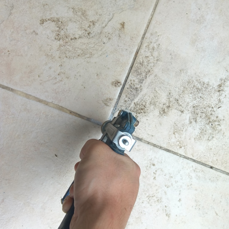 玄関の床タイルの目地からシロアリ駆除剤を注入