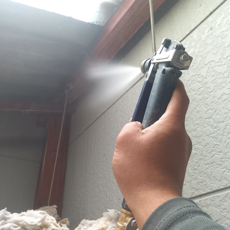 木材にシロアリ駆除剤を吹き付ける様子