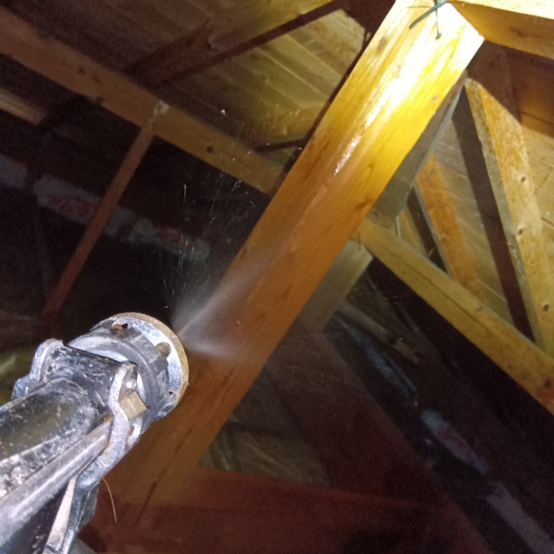屋根裏の木材にシロアリ駆除剤を散布