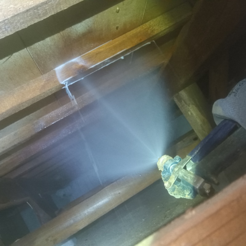 床下木材にシロアリ駆除剤を吹き付けている様子