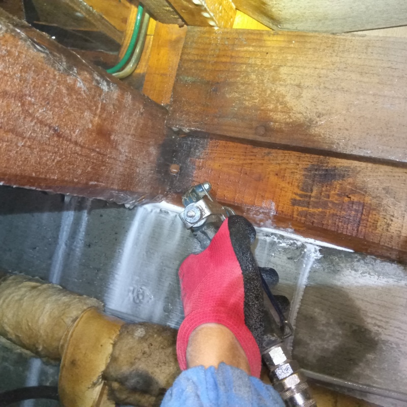 床下木材に防蟻剤を吹き付ける様子